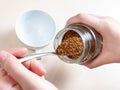 Hand spooning up instant coffee from jar close up Royalty Free Stock Photo