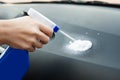 Hand with spray bottle spraying on car Royalty Free Stock Photo