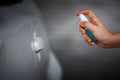 Hand spraying alcohol to cleaning car door handle for protect from infection of virus Covid-19 coronavirus Royalty Free Stock Photo