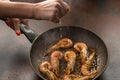 A hand squeezing lemon juice on roasted, grilled shrimp. process of preparation Royalty Free Stock Photo