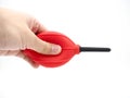 Hand squeezing a red camera air blower isolated on a white background. Royalty Free Stock Photo