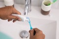 Hand squeezing tooth paste to the brush