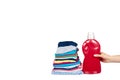 Hand with stack of clothes and detergent bottle, fresh laundry textile Royalty Free Stock Photo