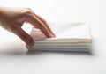 Hand stacking fresh clean white folded fabric stack on a bright background Royalty Free Stock Photo