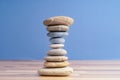 Hand stacking pebbles to make shape of hourglass as a symbol of time management