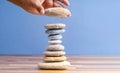 Hand stacking pebbles to make shape of hourglass as a symbol of time management