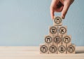 Hand stacking wooden blocks with hebrew letters creating a pyramid structure for learning and education Royalty Free Stock Photo
