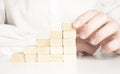 Hand stacking wooden blocks for in shape of staircase. Business development, strategy concept. Building success foundation Royalty Free Stock Photo