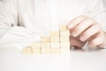 Hand stacking wooden blocks for in shape of staircase. Business development, strategy concept. Building success foundation Royalty Free Stock Photo