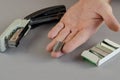 Hand stapler and box of staples against gray background. Man hol Royalty Free Stock Photo