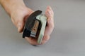 Hand and stapler on gray background. A man holding a plastic pap Royalty Free Stock Photo