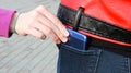 The hand of the stealing person pulls the smartphone out of the back pocket of his jeans Royalty Free Stock Photo