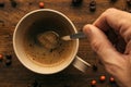 Hand steering coffee in a cup with spoon