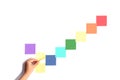 Hand sticking colorful sticky notes on a white background in the shape of a checkmark Royalty Free Stock Photo