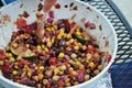 Hand stirring fresh black bean and corn salad in a large serving bowl Royalty Free Stock Photo