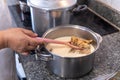Hand stirring salted cod from the pot by removing the salt with milk Royalty Free Stock Photo