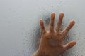 Hand of stranger on frosted glass with water drop