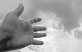 Hand stretched to a sky filled with dark clouds. suitable for book cover,card illustration, presentation. Black and white