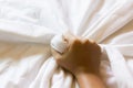 Hand strongly grasp white bed sheet