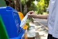 Hand of student girl is throwing away the used protective face mask in the garbage bin,trash bins that separates only a mask and