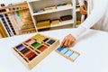 Hand of a student handling montessori material inside a classroom