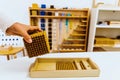 Hand of a student handling montessori material inside a classroom