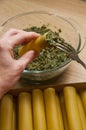 Hand stuffing cannelloni with minced meat and spinach. Ingredients for cooking cannelloni. The process of cooking dinner.