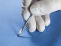 Hand of the surgeon, holding a scalpel. Royalty Free Stock Photo