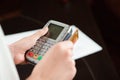 Hand swiping debit card on pos terminal. Business people in office holding a conference and discussing strategies. Royalty Free Stock Photo