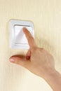 Hand switches on the lightswitch on the wall Royalty Free Stock Photo