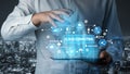 Hand with Tablet Displaying Cloud Computing Concepts and Data Management Icons Over a Cityscape Background at Night Royalty Free Stock Photo