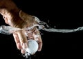 Hand take up Golf ball splashing in water Royalty Free Stock Photo