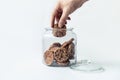 A hand taking cookies from a glass jar on white background Royalty Free Stock Photo