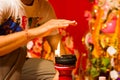 A hand taking heat of the flame as blessing from a lit clay lamp on top of a clay stand or worship idol durgapuja india diwali