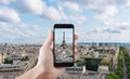 Hand taking photo of Eiffel tower, famous landmark and travel destination in Paris, France by mobile smart phone