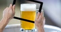 Hand taking picture of beer glass Royalty Free Stock Photo