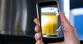 Hand taking picture of beer glass through smart phone at bar Royalty Free Stock Photo