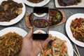 A hand taking a picture of oriental food together with a mobile phone Royalty Free Stock Photo