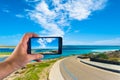 Hand taking picture with smartphone on the beach Royalty Free Stock Photo