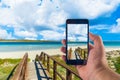 Hand taking picture with smartphone on the beach Royalty Free Stock Photo