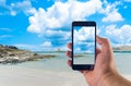 Hand taking picture with smartphone on the beach Royalty Free Stock Photo