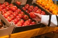 hand taking tomatoes from grocery store shelf Royalty Free Stock Photo
