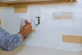 Hand of technician use of rubber classic tile wall texture on new grout tile on tile in the final step for kitchen Royalty Free Stock Photo