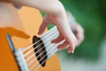 The hand of a teenage girl lying on the strings of a musical instrument guitar Royalty Free Stock Photo