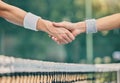 Hand, tennis and handshake for partnership, trust or greeting in sportsmanship over net on the court. Players shaking Royalty Free Stock Photo