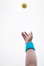 Hand of a tennis player throwing a ball into the air. African american tennis player serving during a game of tennis Royalty Free Stock Photo