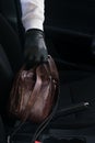 Hand of a thief steals a bag of documents from the car, close-up