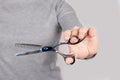 Hand with thinning scissors on grey background