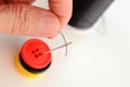 Hand threading a needle with black thread