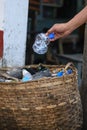 Hand throwing bottle in the basket bin